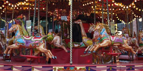 A vintage carousel with brightly painted horses under twinkling lights.