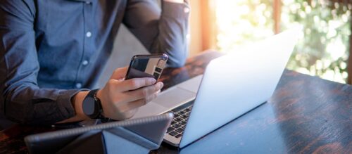 person sitting at desk looking at mobile device