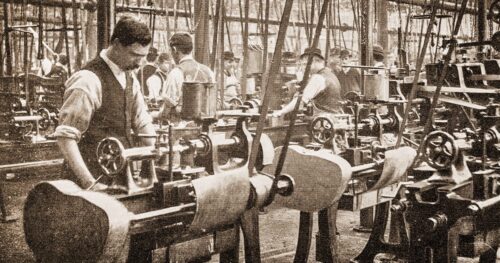 19th Century factory workers operating belt-driven machinery.