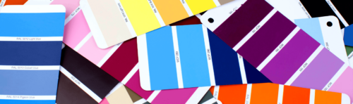A collection of colorful swatches featuring a variety of vibrant hues scattered on a table.